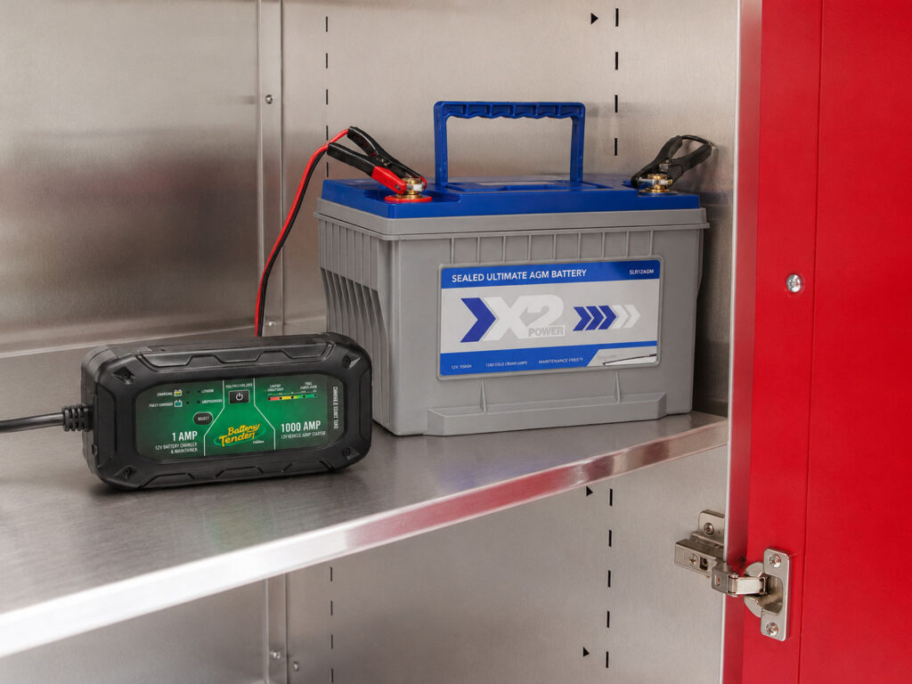 A battery maintainer tucked inside a custom cabinet keeps collector vehicles on a maintenance charge year-round. The charger and leads stay completely out of sight, so the garage looks finished even when the car is plugged in.