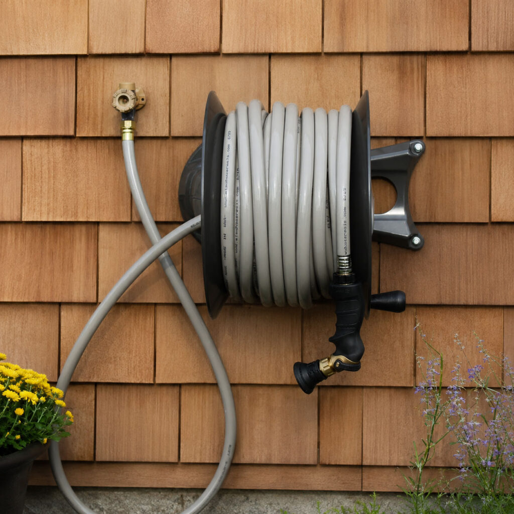 A wall-mounted hose reel keeps the hose coiled, protected, and ready without piling up on the garage floor. Positioned near the opening or a dedicated wash bay, it handles everything from car washing to floor rinsing with no untangling required.